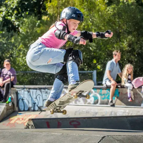 Skater in a pink shirt doing an ollie